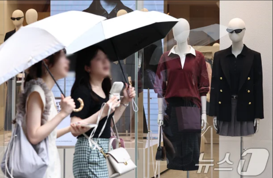 상점의 가을 옷과 상반되는 여름 복장과 선풍기